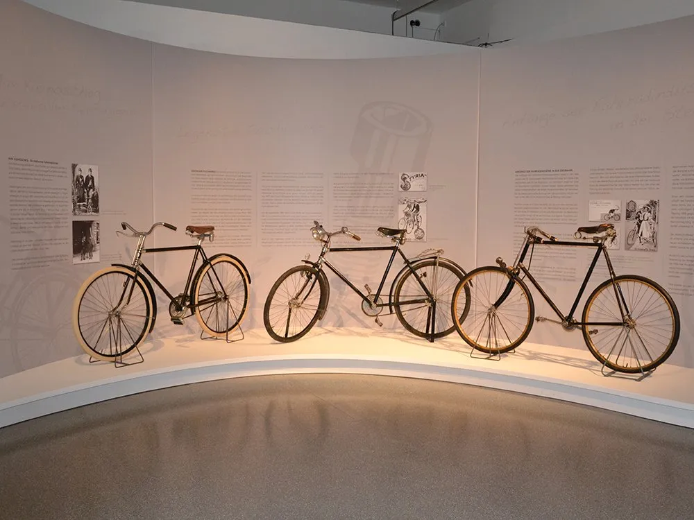 Drei alte Fahrräder entlang runder Wand mit Texten