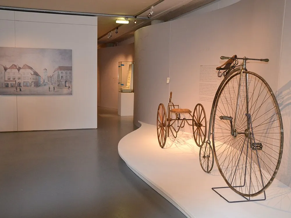 Hochrad und weiters altes Rad auf Podest, Bilder und Texte an Wänden