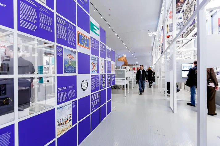 Infowand zu Europa, historische Plakate, Besucher:innen schlendern durch die helle Ausstellung im Haus der Geschichte