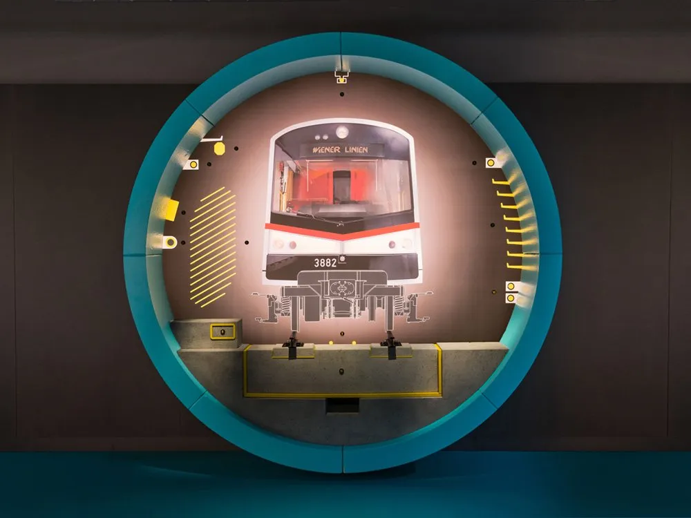 Ausstellungsraum: U-Bahn 3882 mit "Wiener Linien" in türkisfarbenem Rahmen, umgeben von gelben Markierungen