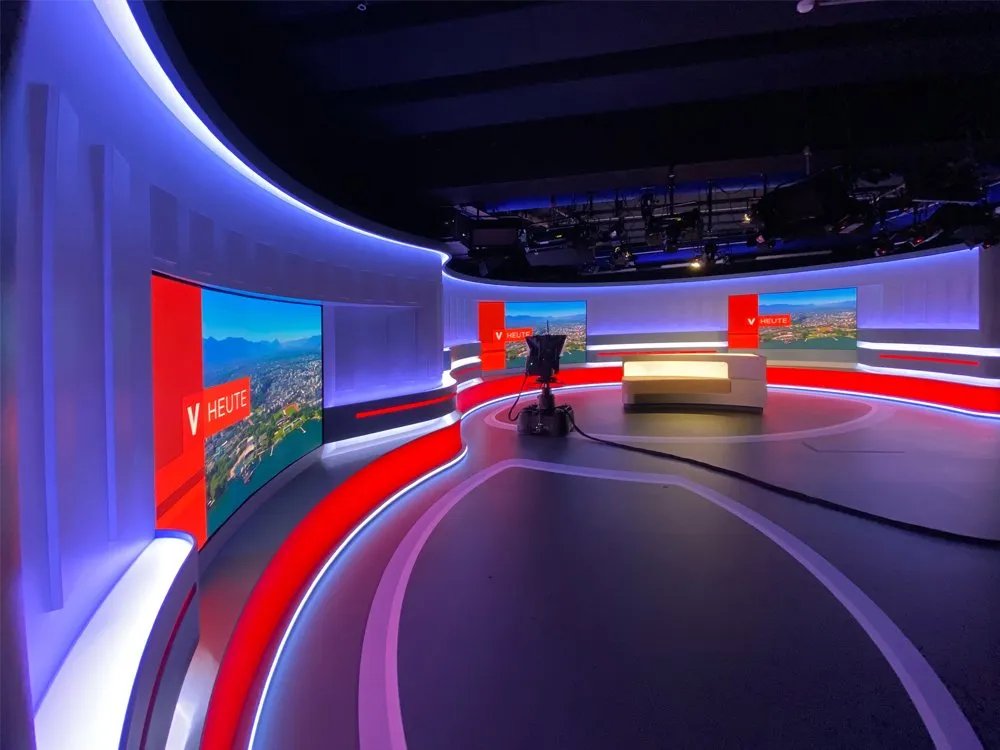 "Vorarlberg heute"-Studio mit halbkreisförmiger Bühne, LED-Wänden und zentralem Pult
