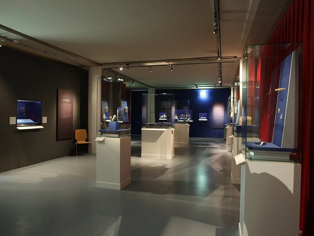 Ausstellungsraum: dunkler Raum mit Vitrinen